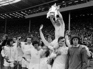 Leeds United captain Billy Bremner holds aloft the trophy as he sits on the shoulders of team-mates Allan Clarke and Peter Lorimer (right) after the Leeds United v Arsenal FA Cup Final held at Wembley stadium, London on the 6th May 1972. Left to right; Mick Bates, Paul Madeley, Paul Reaney, Johnny Giles, Jack Charlton, Allan Clarke, Billy Bremner, Peter Lorimer and David Harvey. Leeds United won the match 1-0.   (Photo by Bob Thomas/Getty Images)